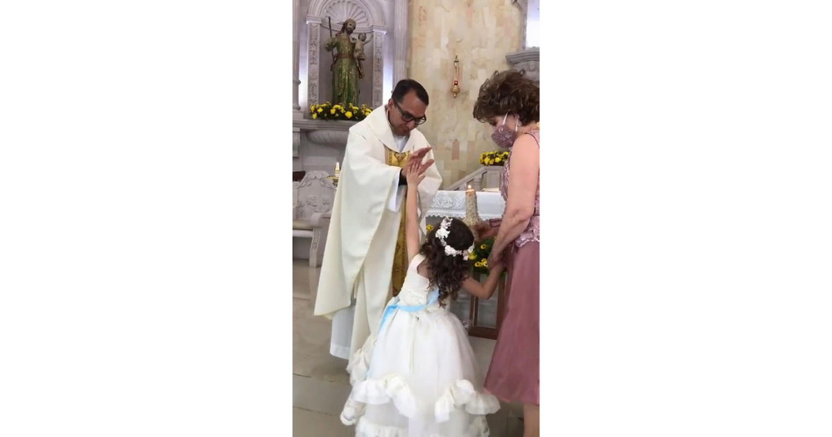 Little Girl High Fives Priest While He Blesses Her