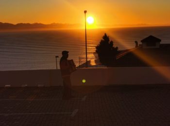 Oom speel trekklavier vir siek vrou deur hospitaalvenster (Foto: Mossel Bay Advertiser)